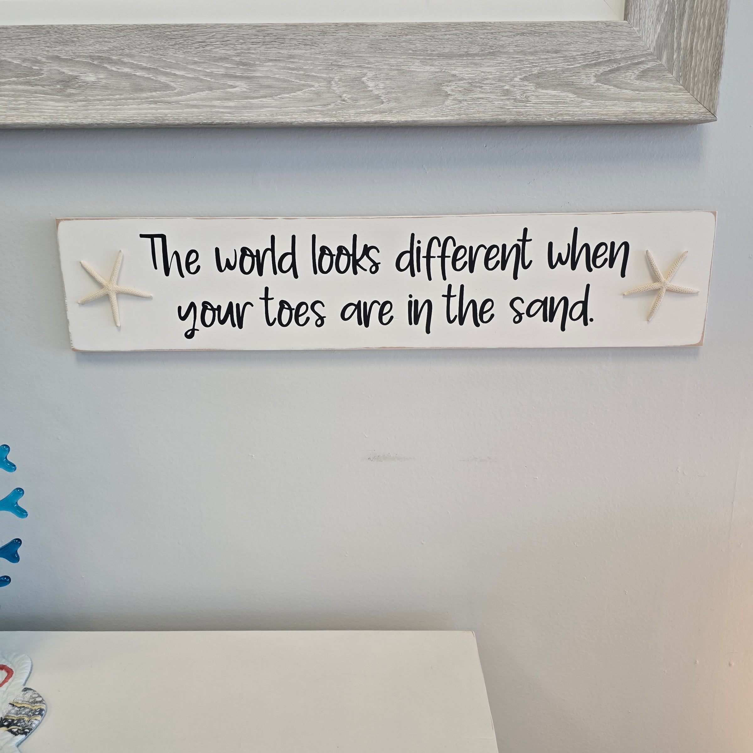"The world looks different when" hanging sign